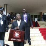 Finance minister Matia Kasaija carrying the briefcase containing his budget speech