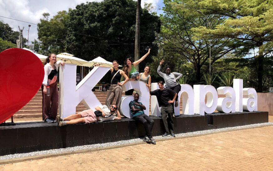 dutch toursits taking a picture at the kampala sign at the independence monument