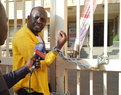 Former Isingiro North Aspirant Chains Himself at UNEB Over Withheld Academic Documents